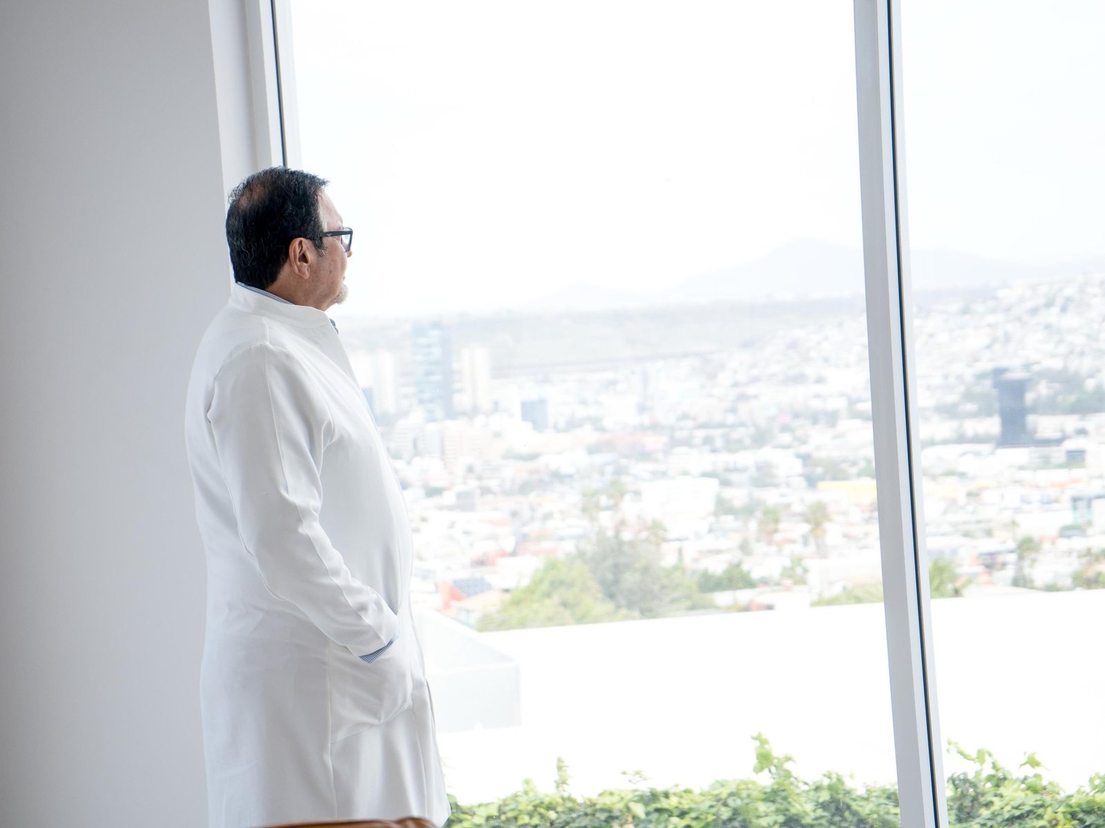 A BMC Clinic physician at the window, with Tijuana behind
