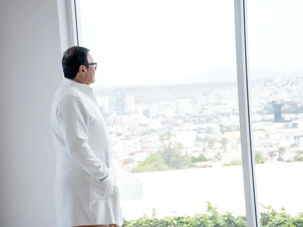A BMC Clinic physician at the window, with Tijuana behind